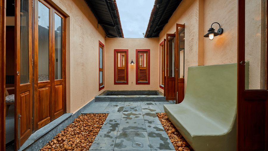 An open courtyard featuring a stone path, gravel edges, and a green concrete bench at Hotel Sonar Bangla, Ajodhya Hills.