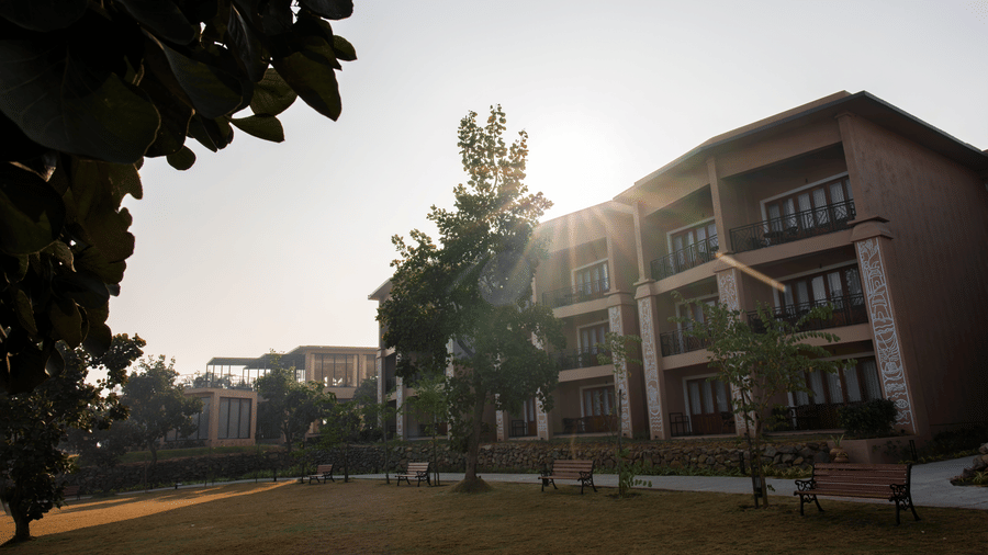 An exterior view featuring multi-storey buildings, a lawn, and trees at Hotel Sonar Bangla, Ajodhya Hills.