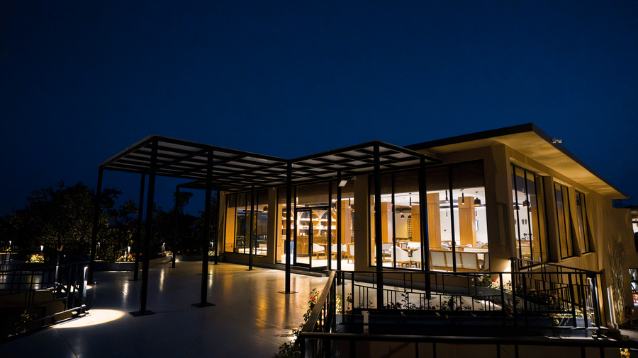 A lit building exterior at night featuring a patio at Hotel Sonar Bangla, Ajodhya Hills.