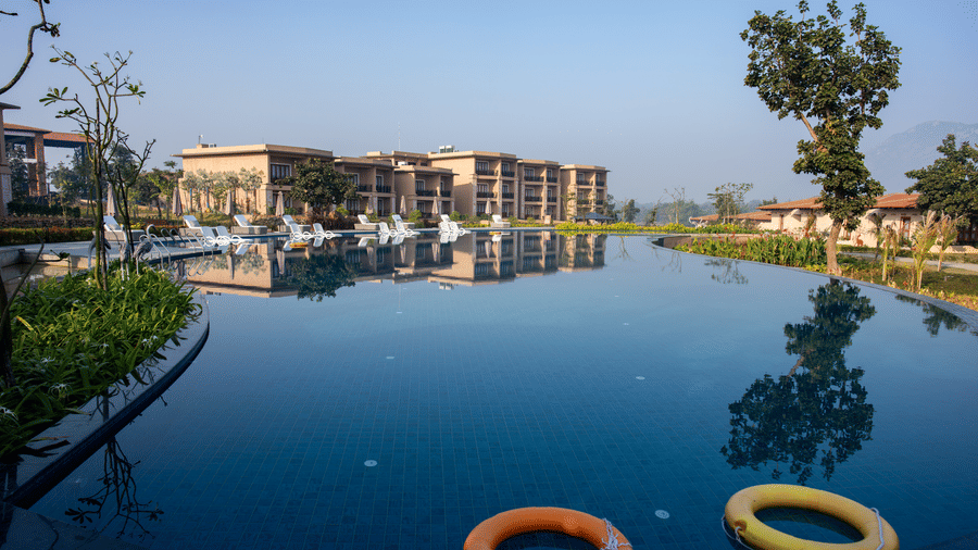 A view of a swimming pool featuring 2 floating orange life rings and building reflections at Hotel Sonar Bangla, Ajodhya Hills.