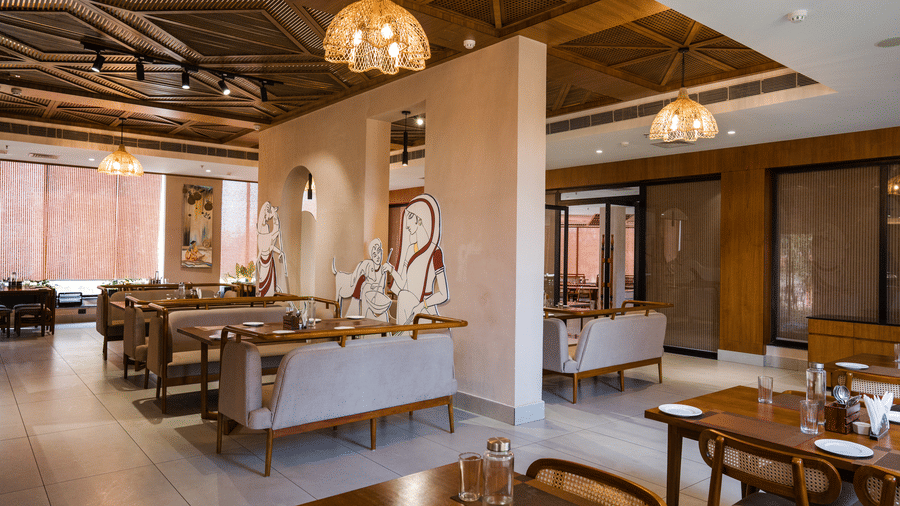 A restaurant featuring wooden dining tables, seating, and a decorative ceiling at Hotel Sonar Bangla, Ajodhya Hills.