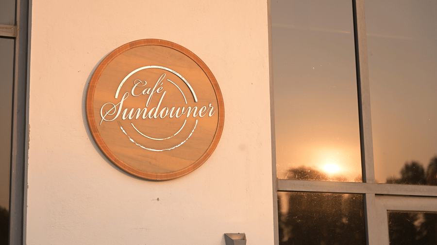Close-up of the Sundowner name plaque mounted on the building wall at Hotel Sonar Bangla, Mayapur.