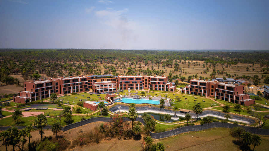 A wide aerial view showcasing the circular resort layout, landscaped gardens, and the central swimming pool area from above | Hotel Sonar Bangla, Susunia