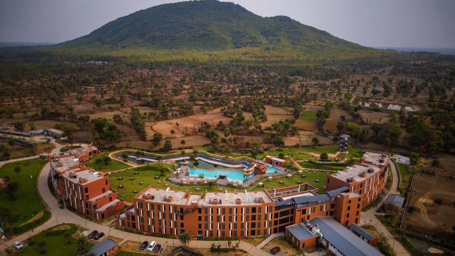 An aerial daytime view of the resort surrounded by natural landscapes with the Susunia Hill rising in the background | Hotel Sonar Bangla, Susunia