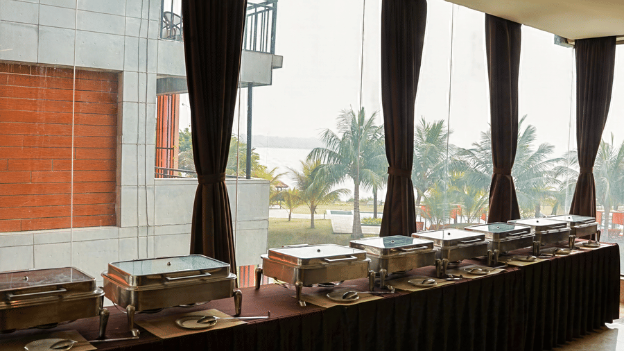 Buffet setup featuring chafing dishes setup on tables at Hotel Sonar Bangla, Taki.
