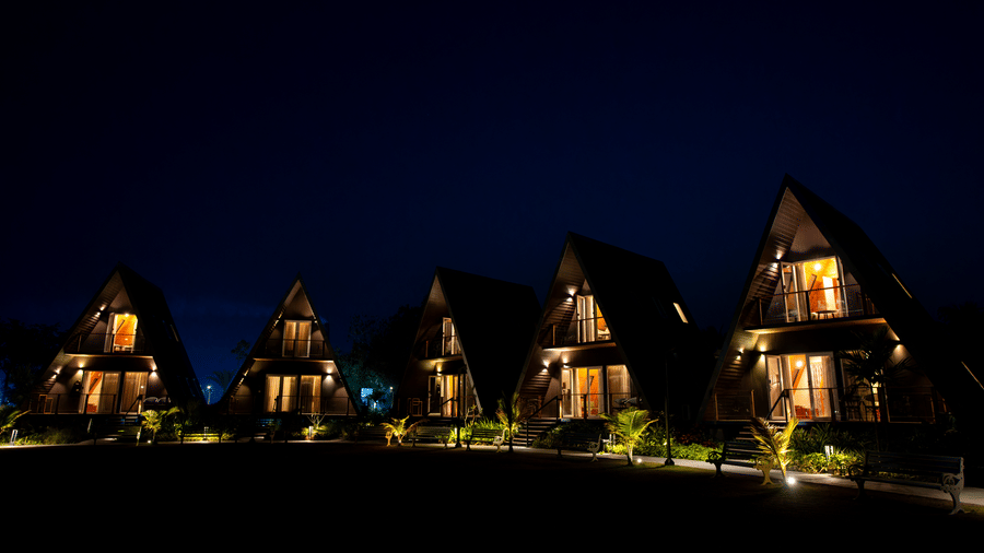 Cluster of illuminated villa units reflected at night at Hotel Sonar Bangla, Taki.