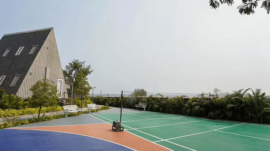 Exterior view from Hotel Sonar Bangla, Taki, over a playground surrounded by trees.