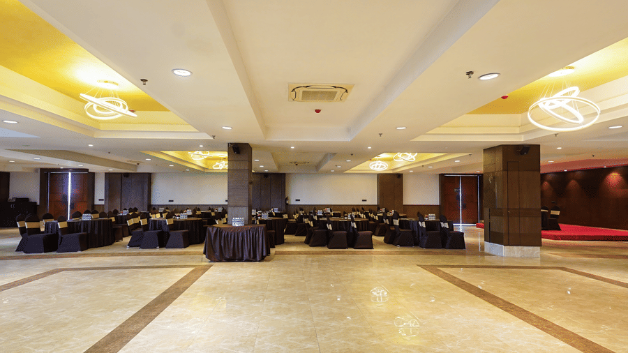 Banquet hall arranged for a dinner event with chair covers at Hotel Sonar Bangla, Taki.