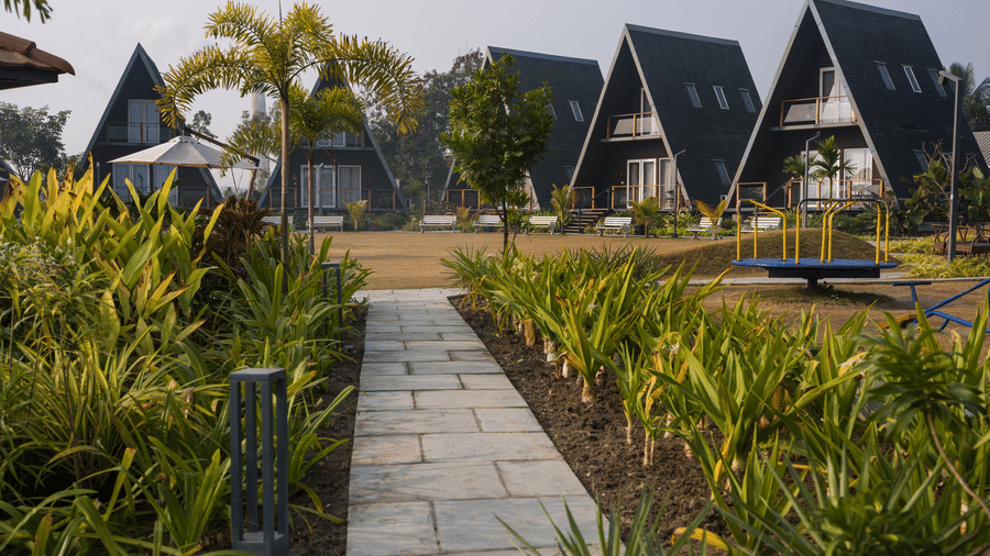 Row of duplex cottage-style villas with a garden pathway at Hotel Sonar Bangla, Taki.