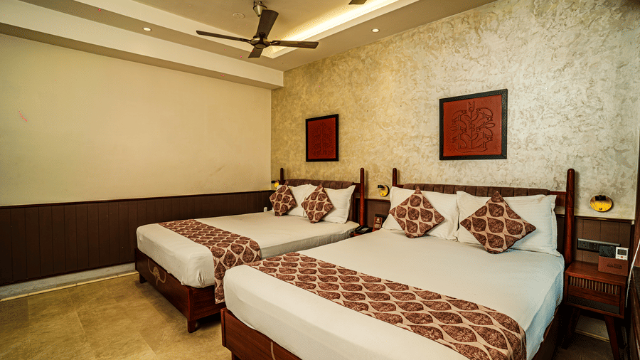 A hotel room featuring 2 double beds, wooden decor, marble flooring, and warm lights | Hotel Sonar Bangla, Tarapith