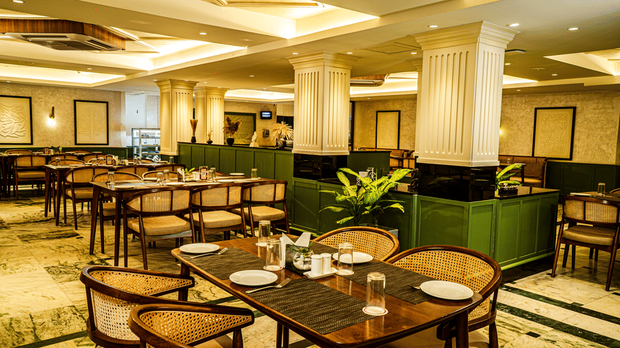 Large luxury dining hall with wooden tables, marble flooring, decorative lights, and elegant seating arrangements | Hotel Sonar Bangla, Tarapith