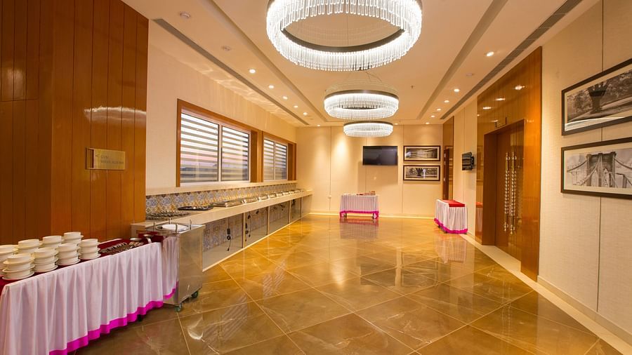 A hotel buffet area with a large chandelier, marble floors and a catering setup - Hotel Southend by TGI - Bommasandra, Bangalore