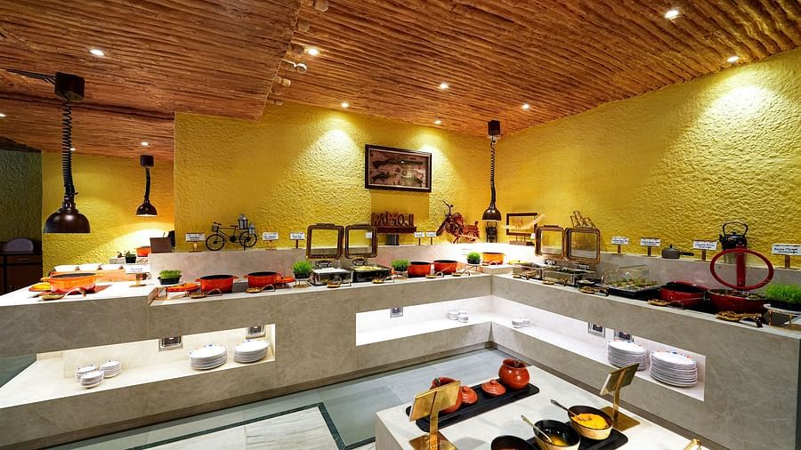 A full view of a buffet area with various food stations and a warm, inviting ambiance. - Tara, Comfort Hotel in Hyderabad - Ramoji Film City.