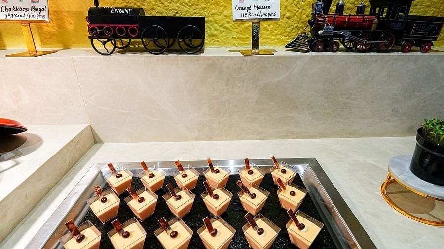 An array of individual desserts neatly presented in glass containers on a buffet counter. - Tara, Comfort Hotel in Hyderabad - Ramoji Film City.