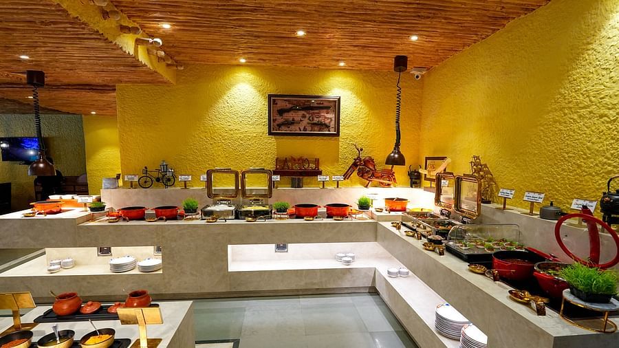 A restaurant buffet area, warmly lit, offering a variety of culinary delights. - Tara, Comfort Hotel in Hyderabad - Ramoji Film City.