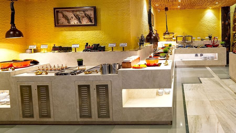 Buffet counters with a selection of food, under elegant pendant lighting at Tara, Comfort Hotel in Hyderabad - Ramoji Film City.