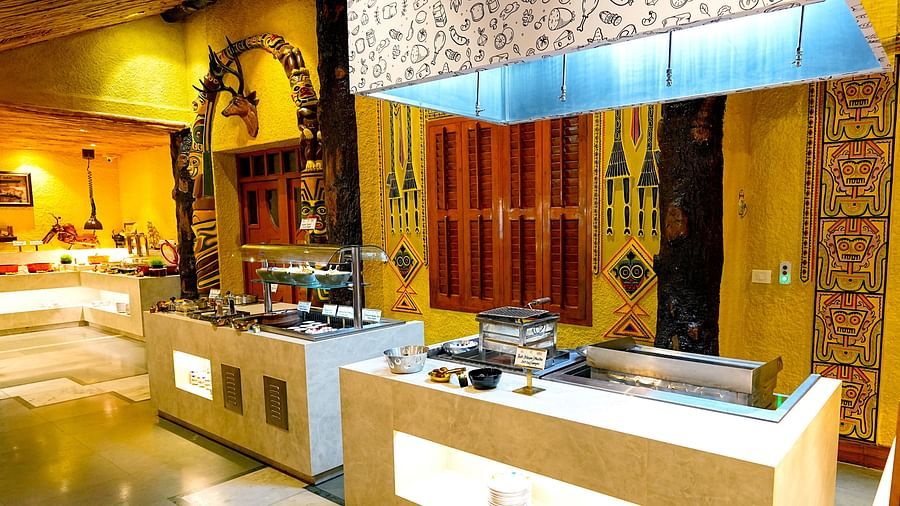 A modern buffet area with sleek service counters and decorative lighting at Tara, Comfort Hotel in Hyderabad - Ramoji Film City.