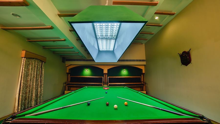 Pool table with billiards cue sticks placed at the corners at Tara, Comfort Hotel in Hyderabad - Ramoji Film City.