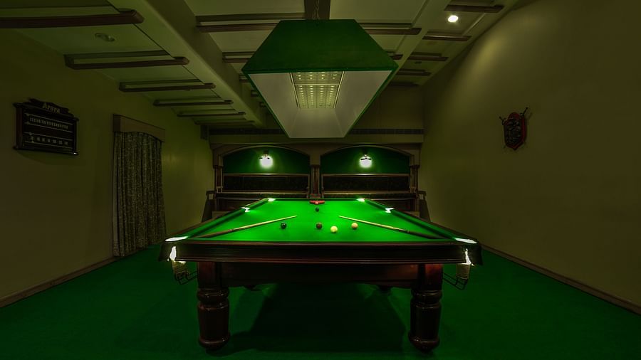 Pool table with billiards cue sticks placed at the corners at Tara, Comfort Hotel in Hyderabad - Ramoji Film City.