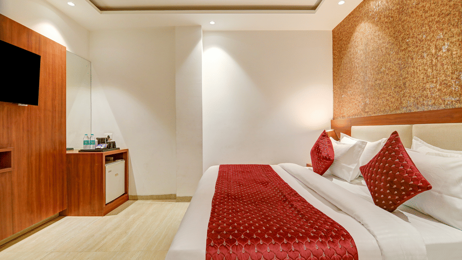 Close-up of a neatly made bed with red quilted pillows and a matching bed runner - Hotel Velocity