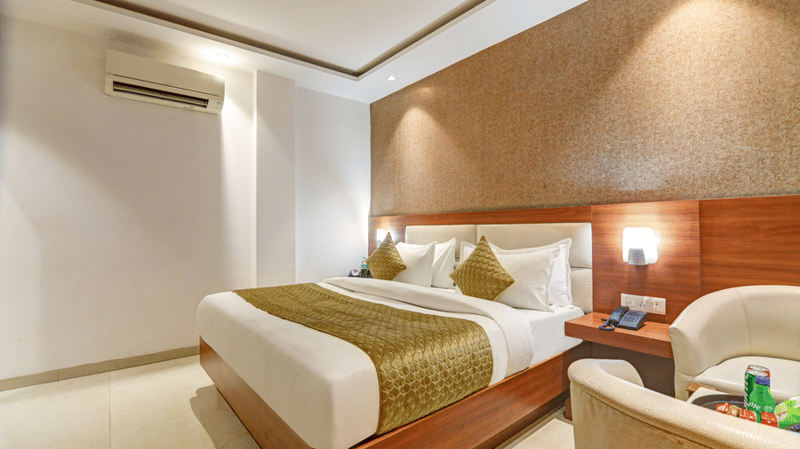 Spacious room with gold decor, air conditioning, and elegant ambient lighting - Hotel Velocity