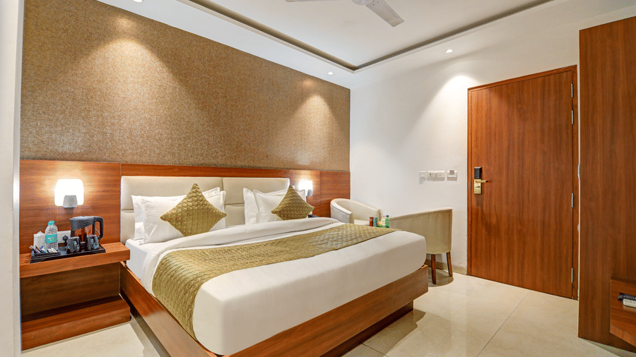 Comfortably furnished king bedroom with warm ambient lighting and gold accent pillows - Hotel Velocity
