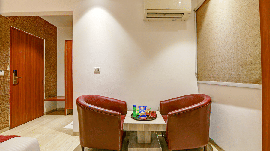 Interior shot of a hotel room featuring two brown leather tub chairs and a small coffee table - Hotel Velocity