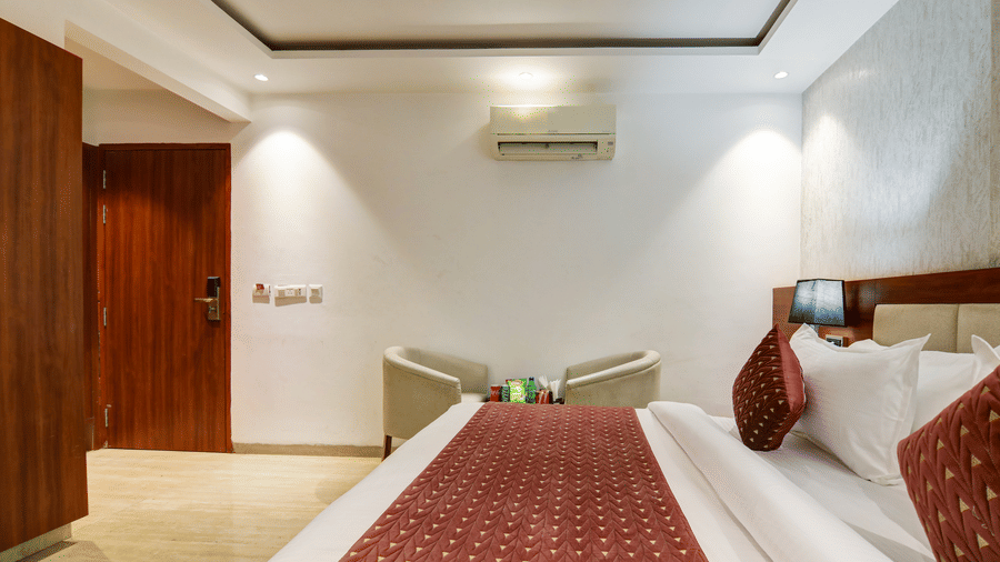 High-angle shot of a hotel room showing the wooden door, seating area, and bed - Hotel Velocity