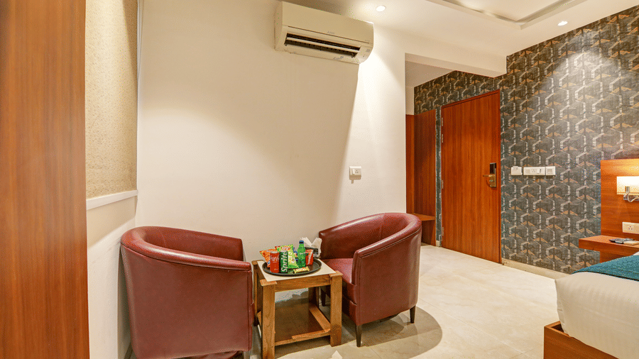 View of the room entrance featuring a small seating area and split air conditioning unit - Hotel Velocity