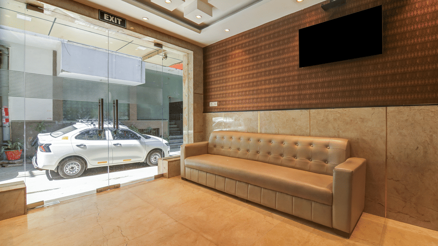 Bright hotel lobby entrance featuring a large tufted sofa and glass doors - Hotel Velocity