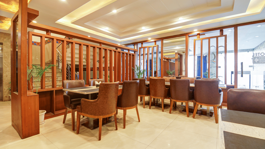 Perspective view of the dining hall featuring wooden partition screens and cosy seating - Hotel Velocity