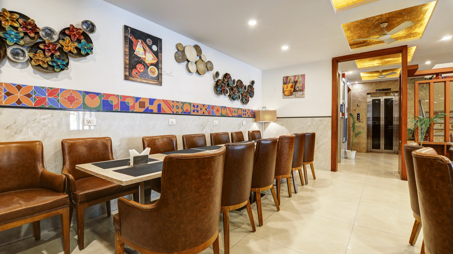 Comfortable leather chairs and long dining tables decorated with wall art in the hotel cafe - Hotel Velocity