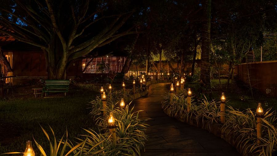 a dimly lit garden pathway at hoysala village resort, hassan
