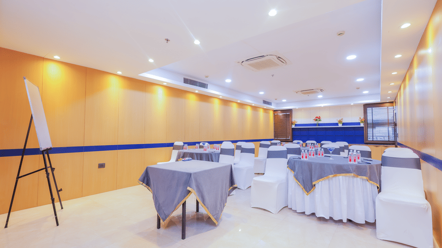 A large event space configured with round tables and chairs, suitable for a banquet or conference - Hyphen Business Hotel, Noida