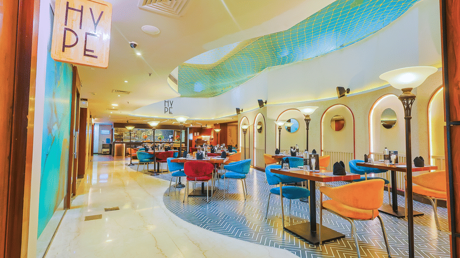 A vibrant restaurant interior with bright seating and contemporary design elements - Hyphen Business Hotel, Noida