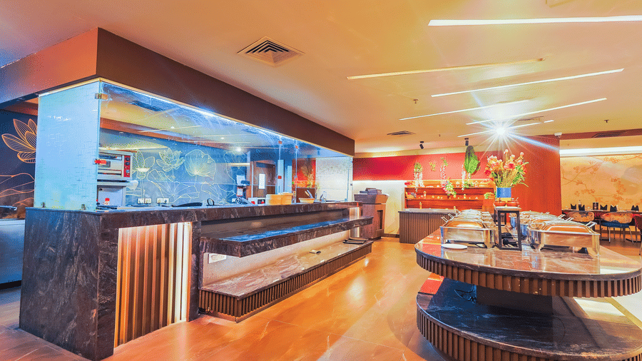 The contemporary serving area of a restaurant with wooden panelling and warm lighting - Hyphen Business Hotel, Noida