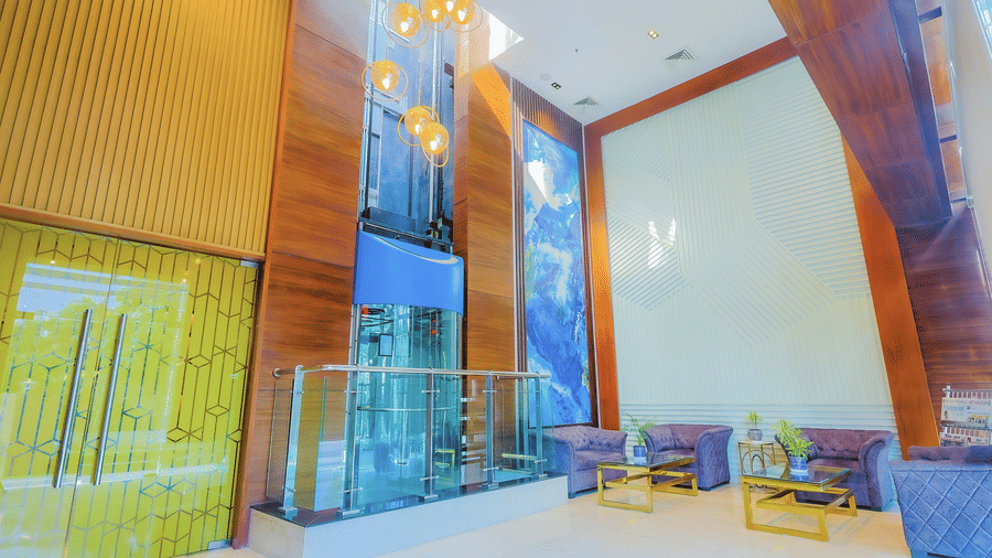 A modern hotel lobby with high ceilings, large glass panels, and contemporary seating - Hyphen Business Hotel, Noida