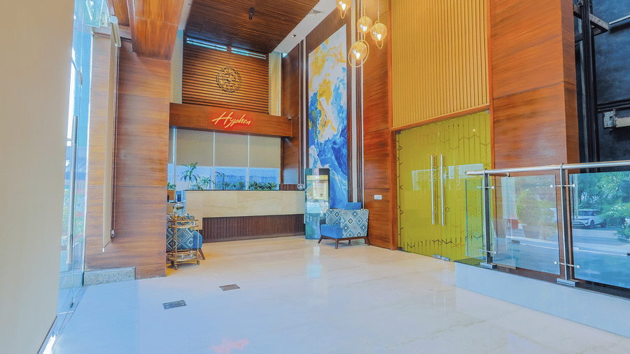 A contemporary hotel reception area with light coloured flooring and modern design elements - Hyphen Business Hotel, Noida