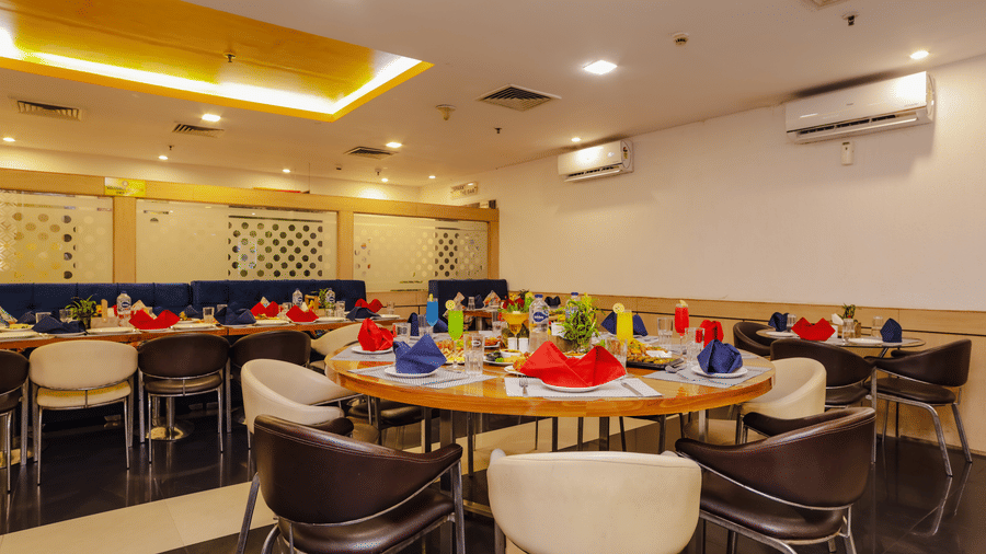 A restaurant space with an array of tables and chairs, ready for dining - Hyphen Grand, Haridwar