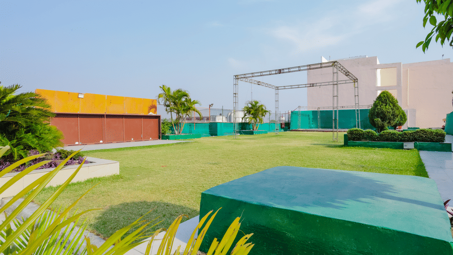 A green rooftop event space with pathways and sparse foliage - Hyphen Grand, Haridwar