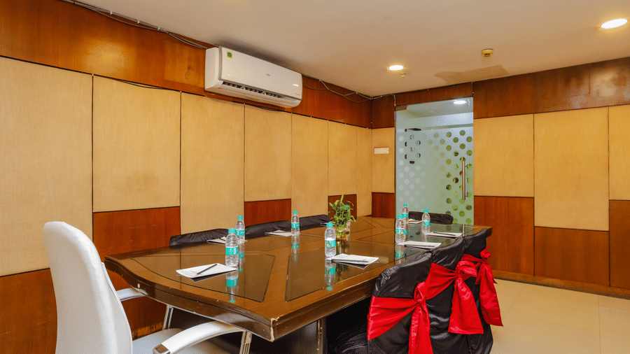 Another view of the compact boardroom showing a glass panelled door and meeting setup - Hyphen Grand, Haridwar