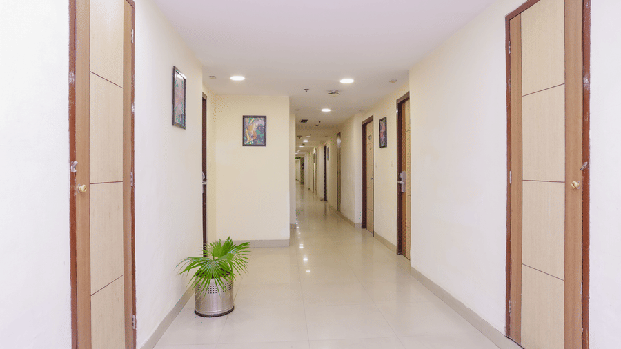 A modern hotel room with a single bed, a wall mounted television, and a small desk - Hyphen Grand, Haridwar