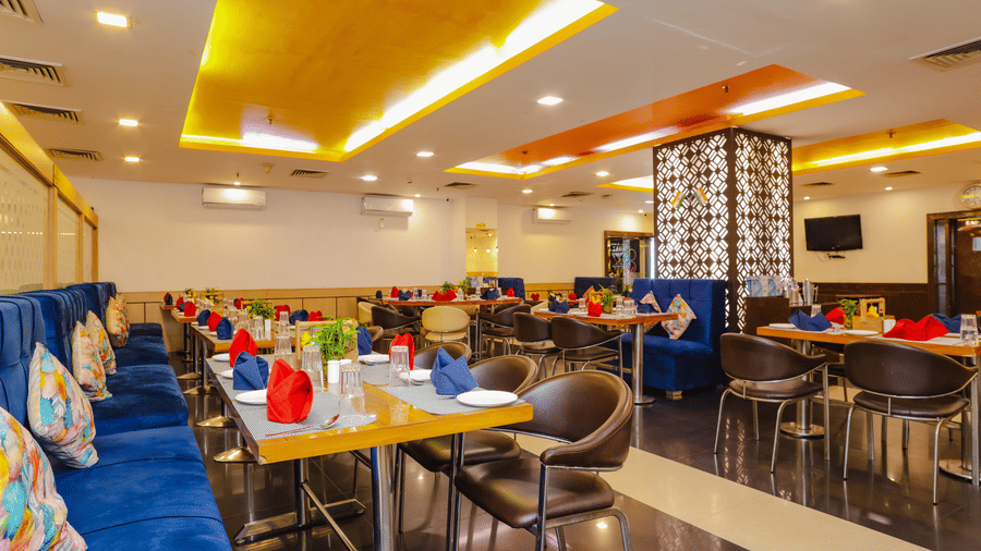 A restaurant with a mix of seating styles and warm lighting, creating an appealing dining environment - Hyphen Grand, Haridwar