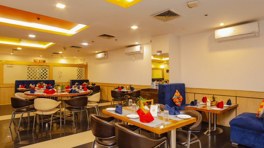A vibrant restaurant dining area with booths and chairs - Hyphen Grand, Haridwar