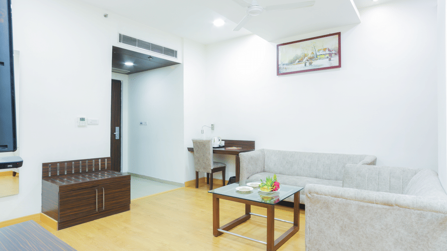 Spacious, brightly lit lounge area at Hyphen Premier Hotel, Meerut, with comfortable seating and minimalist decor.