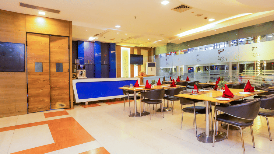 Dining area featuring vibrant colors and elegant lighting at Cafe Treat - Hyphen Premier Hotel, Meerut.