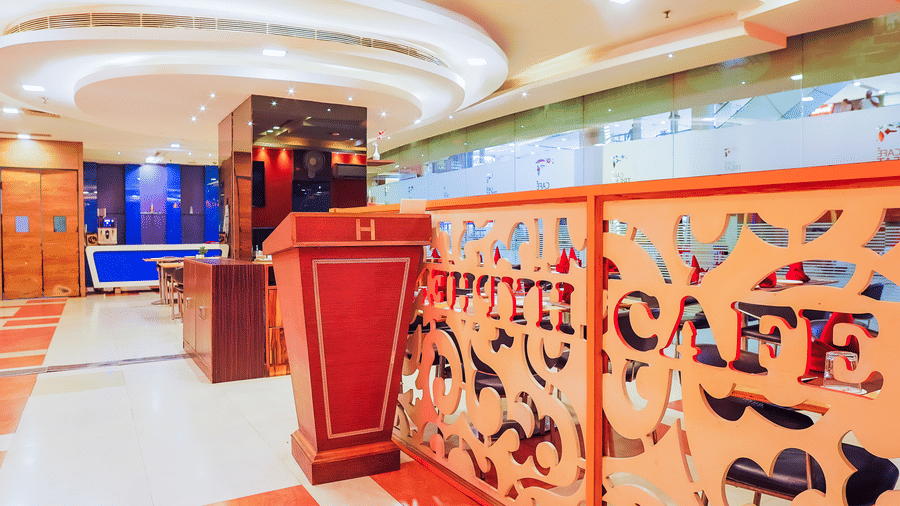 Entrance of Cafe Treat restaurant with partition at Hyphen Premier Hotel, Meerut.