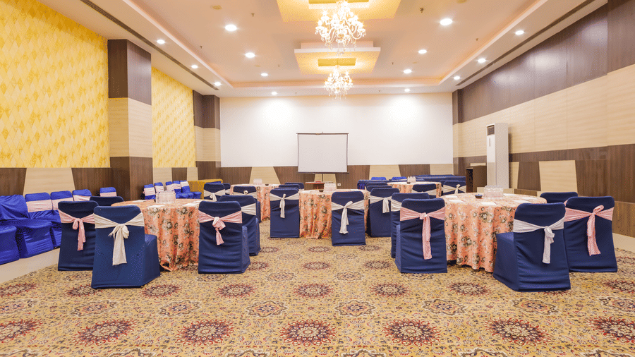 Back view of cluster seating arrangement in a banquet hall at Hyphen Premier Hotel, Meerut.