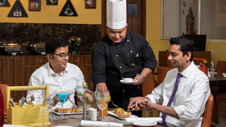 Image of a chef serving food to two people at Cafe Inde | Inde Hotel Cyber City