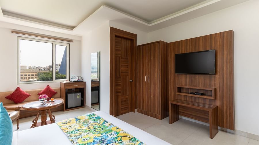 Side view of a spacious hotel room featuring a king size bed, comfortable seating, and modern amenities | Inde Hotel Cyber City 
